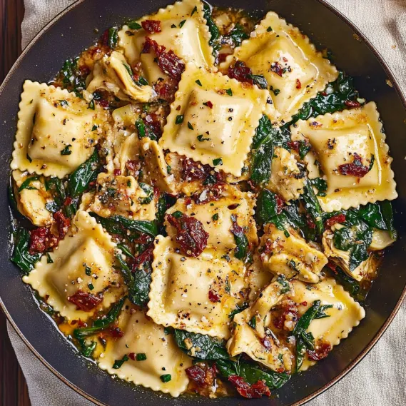 A bowl of pasta with spinach and tomatoes.