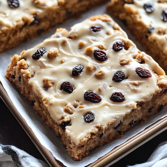 A piece of cake with raisins on top.