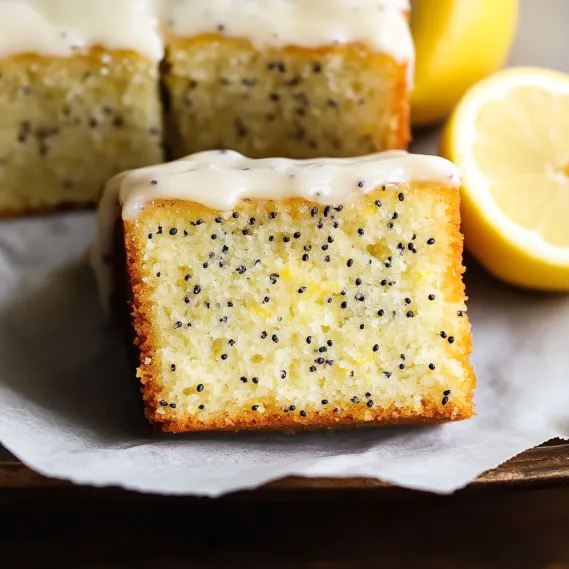 A slice of cake with lemon and poppy seeds.