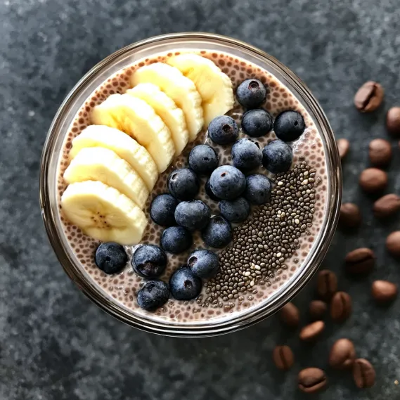 A glass of yogurt with blueberries and bananas.