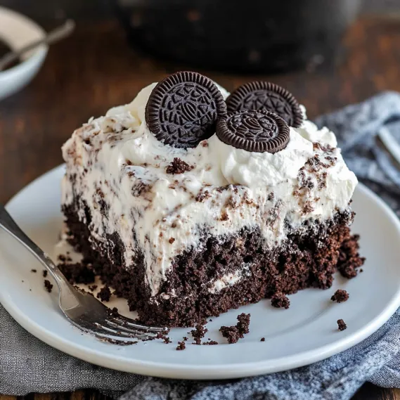 A slice of chocolate cake with two Oreo cookies on top.