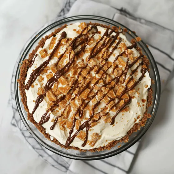 A pie with chocolate drizzled on top.