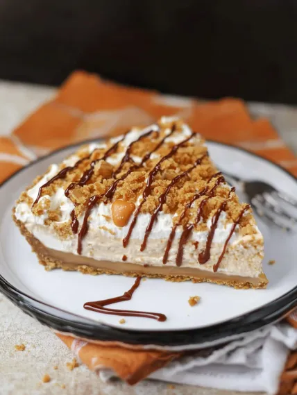 A slice of pie with chocolate and caramel drizzle.