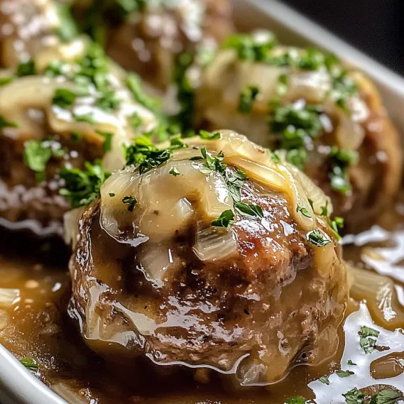 A plate of food with onions and meatballs.