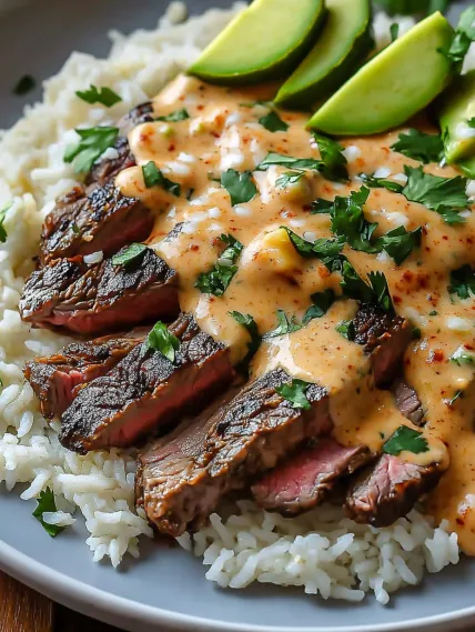 A plate of rice and meat with a sauce.