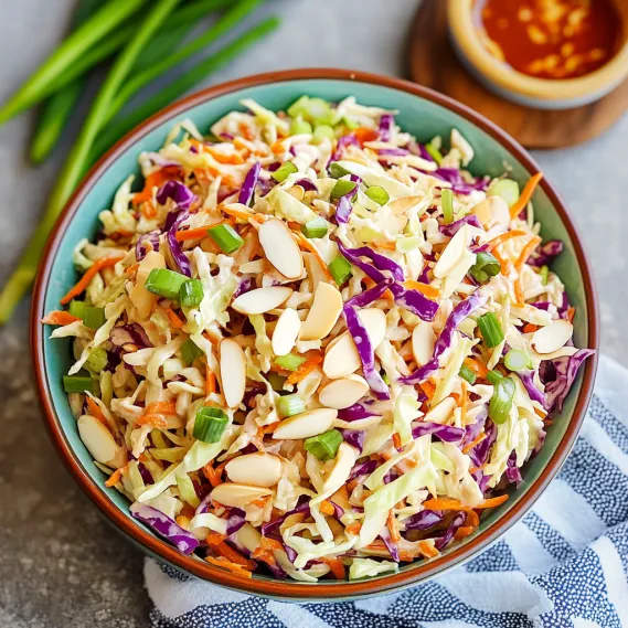 A bowl of coleslaw with carrots and almonds.