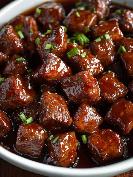 A bowl of meat with green onions.
