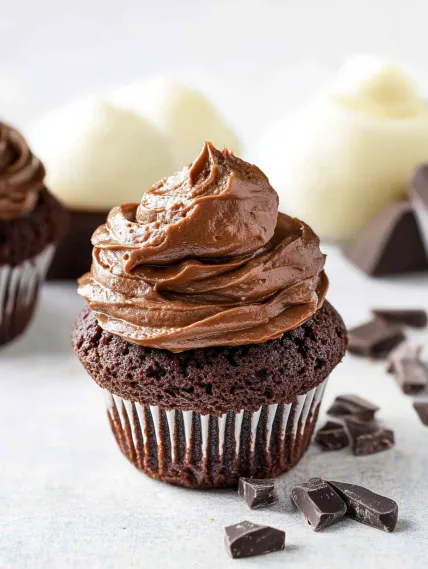 A cupcake with chocolate frosting and chocolate sprinkles.