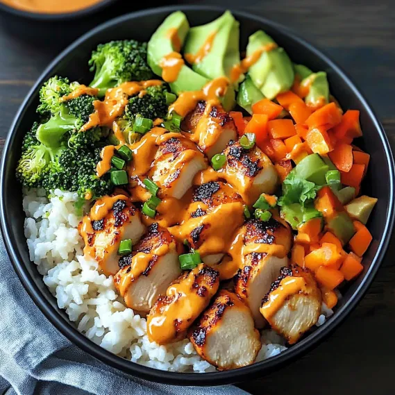A bowl of food with rice, broccoli, carrots, and chicken.