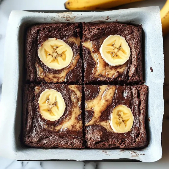 A square of chocolate cake with bananas on top.