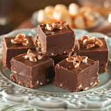 A plate of chocolate fudge squares topped with chopped nuts.